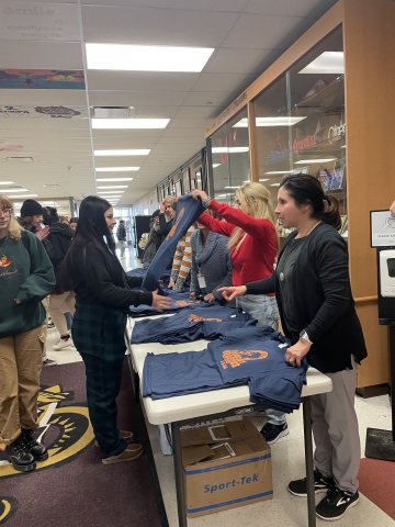 administration handing out shirts to students 