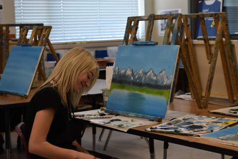 Student's complete their paintings in art class